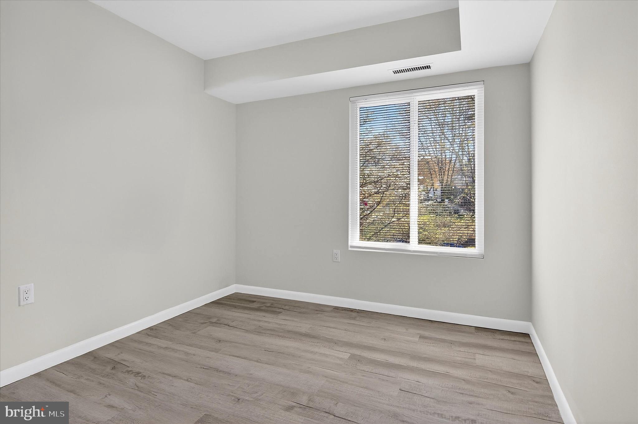 10340 Luria Commons Court, Unit 3H Burke, VA 22015 - Photo 11 of 21 wooden floor in an empty room with a window