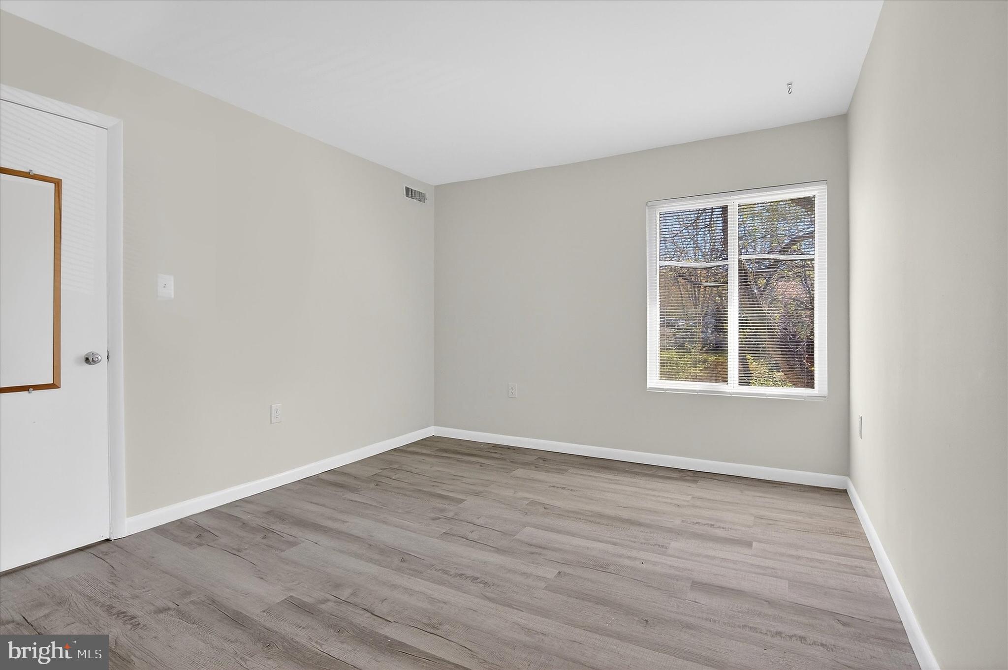 10340 Luria Commons Court, Unit 3H Burke, VA 22015 - Photo 13 of 21 an empty room with wooden floor and windows