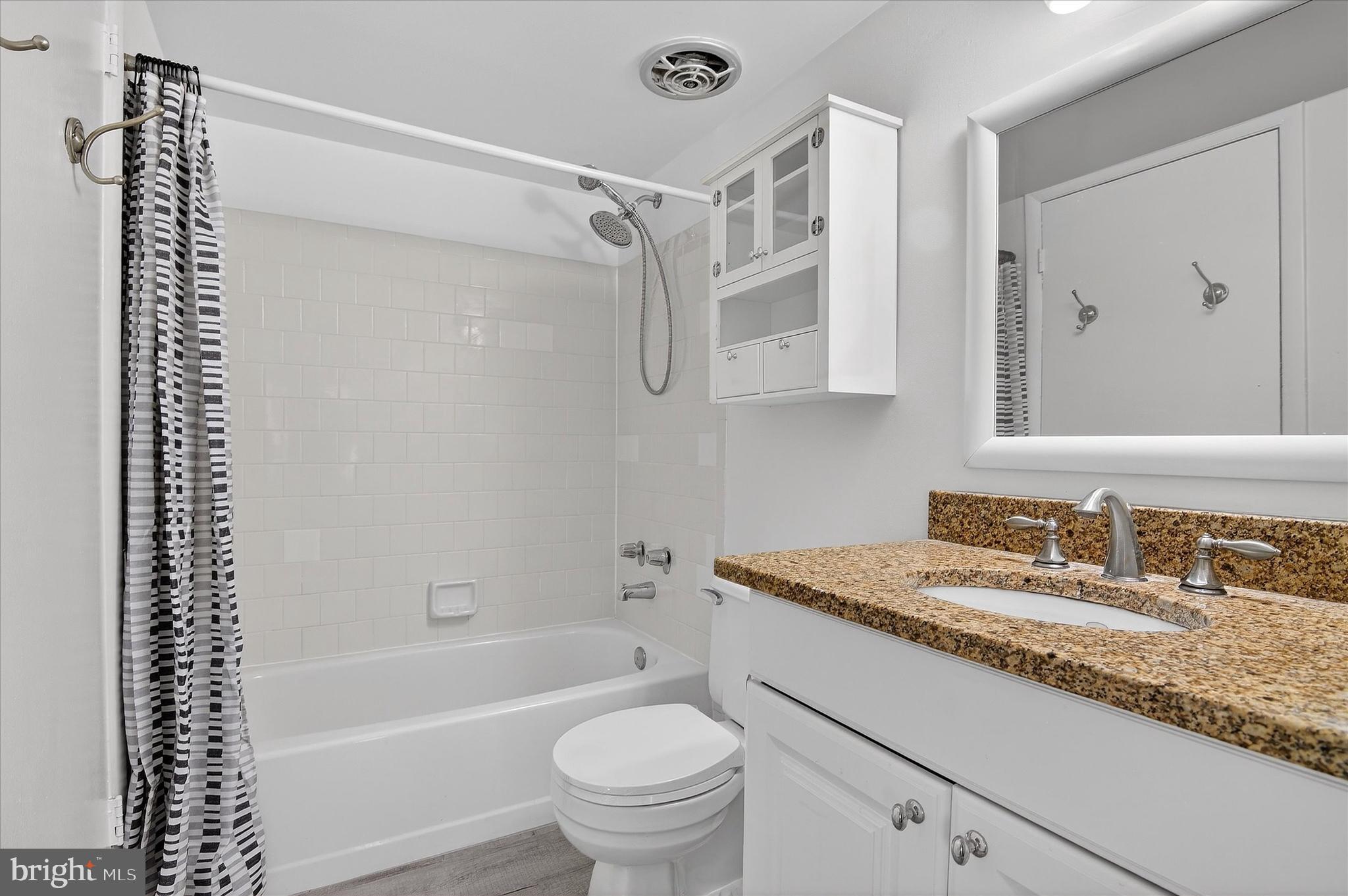 10340 Luria Commons Court, Unit 3H Burke, VA 22015 - Photo 16 of 21 a bathroom with a granite countertop sink a toilet and shower