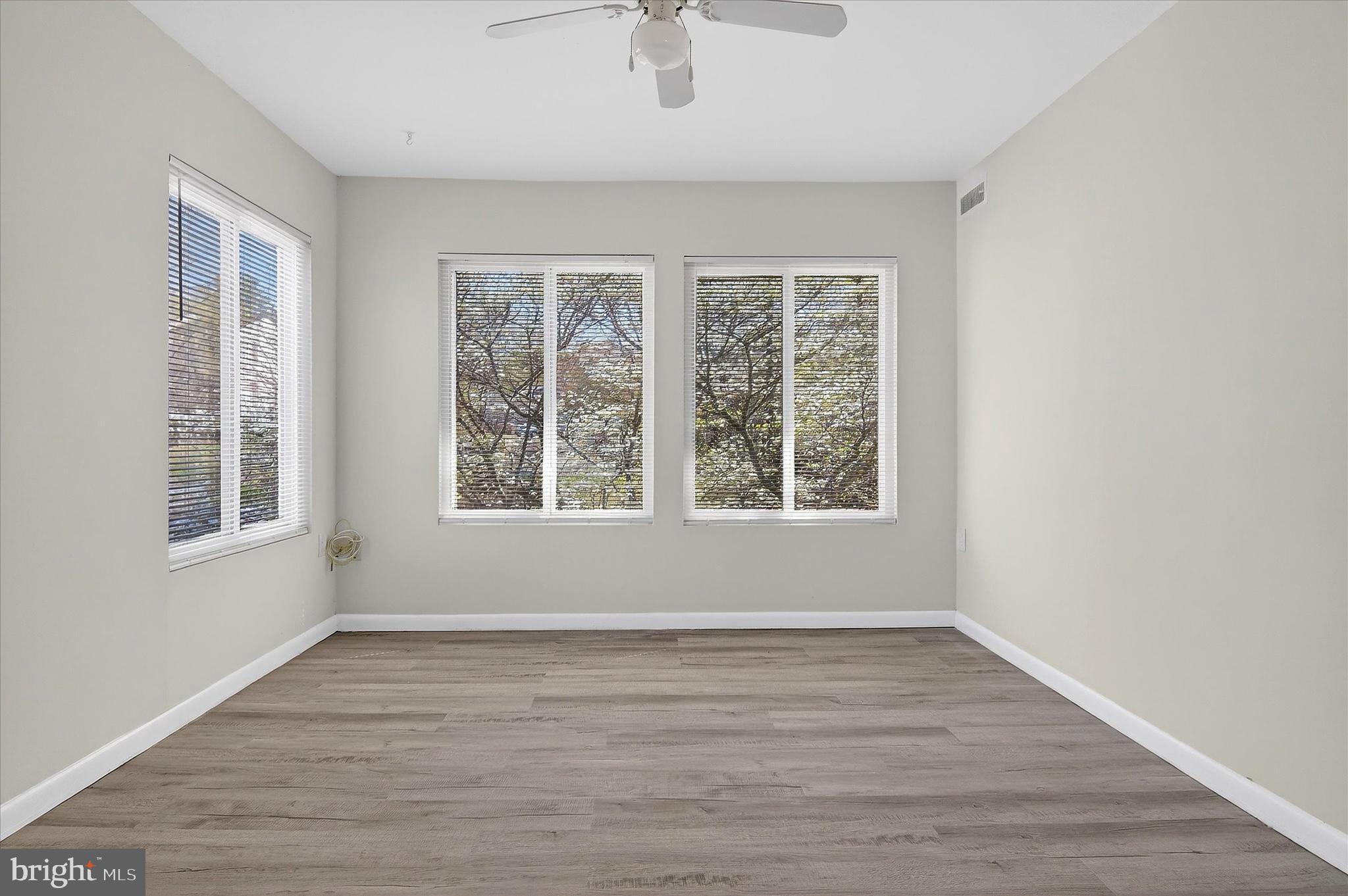 10340 Luria Commons Court, Unit 3H Burke, VA 22015 - Photo 2 of 21 an empty room with wooden floor and windows
