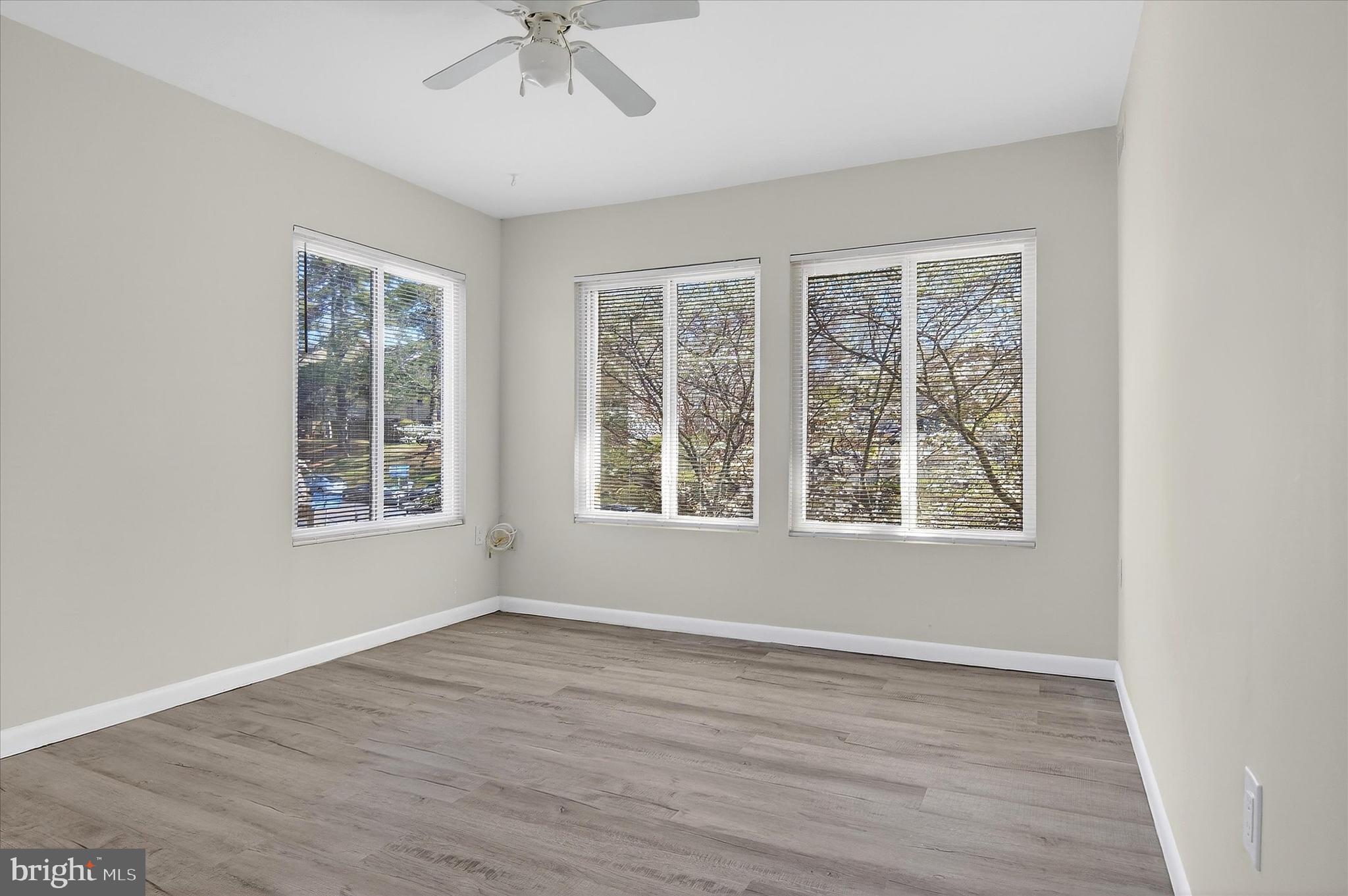 10340 Luria Commons Court, Unit 3H Burke, VA 22015 - Photo 3 of 21 a view of an empty room with a window and wooden floor
