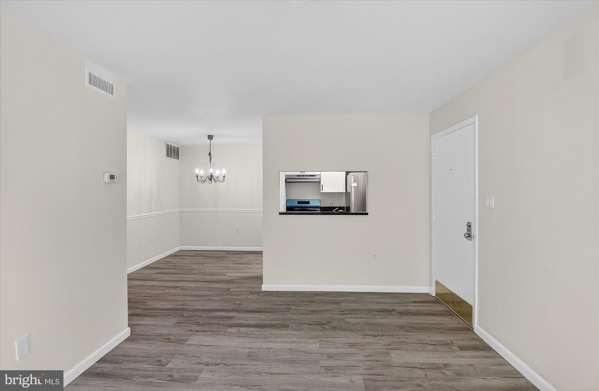 10340 Luria Commons Court, Unit 3H Burke, VA 22015 - Photo 4 of 21 a view of a hallway with wooden floor and a cabinet
