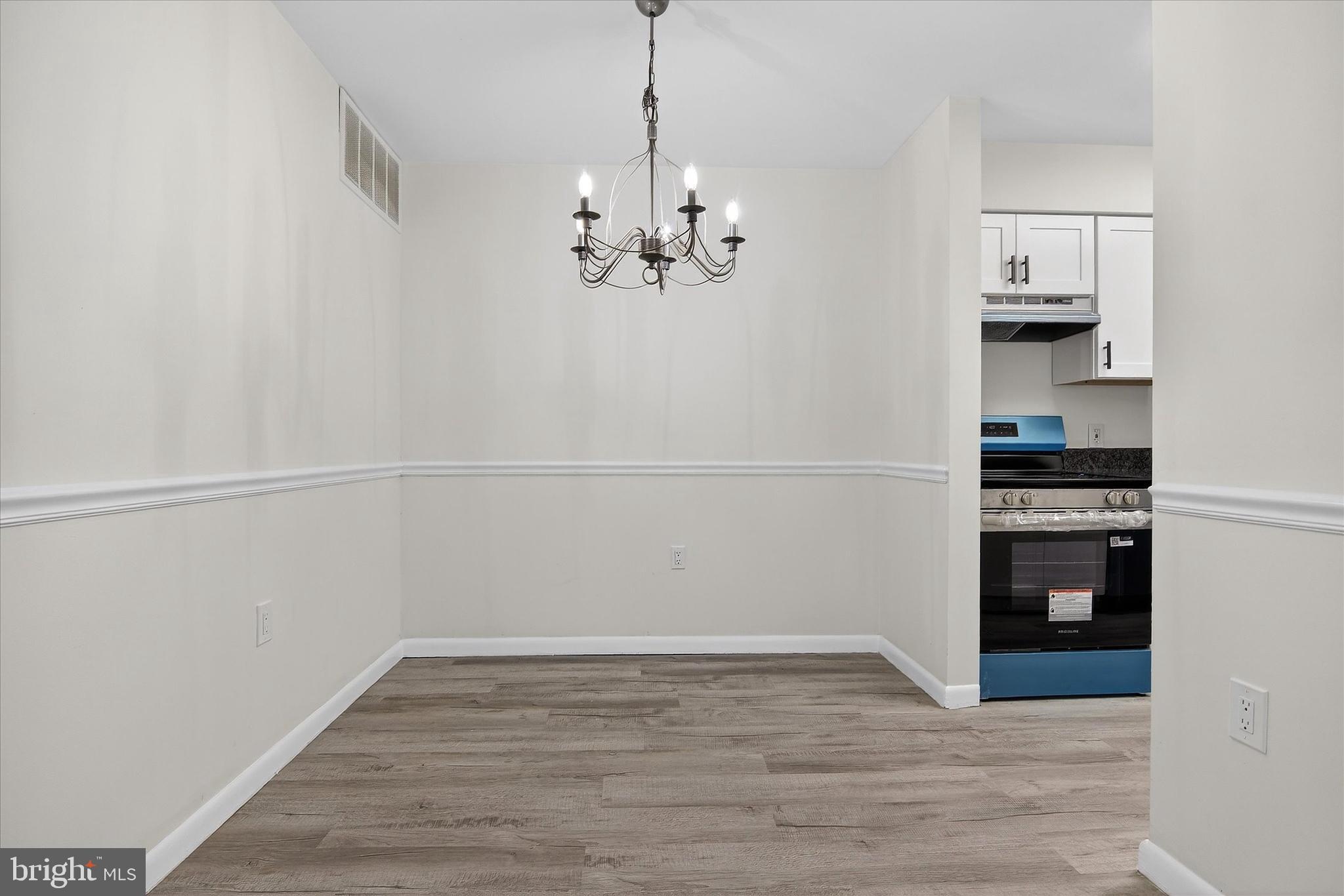 10340 Luria Commons Court, Unit 3H Burke, VA 22015 - Photo 6 of 21 a view of a kitchen with a refrigerator a stove top oven and cabinets