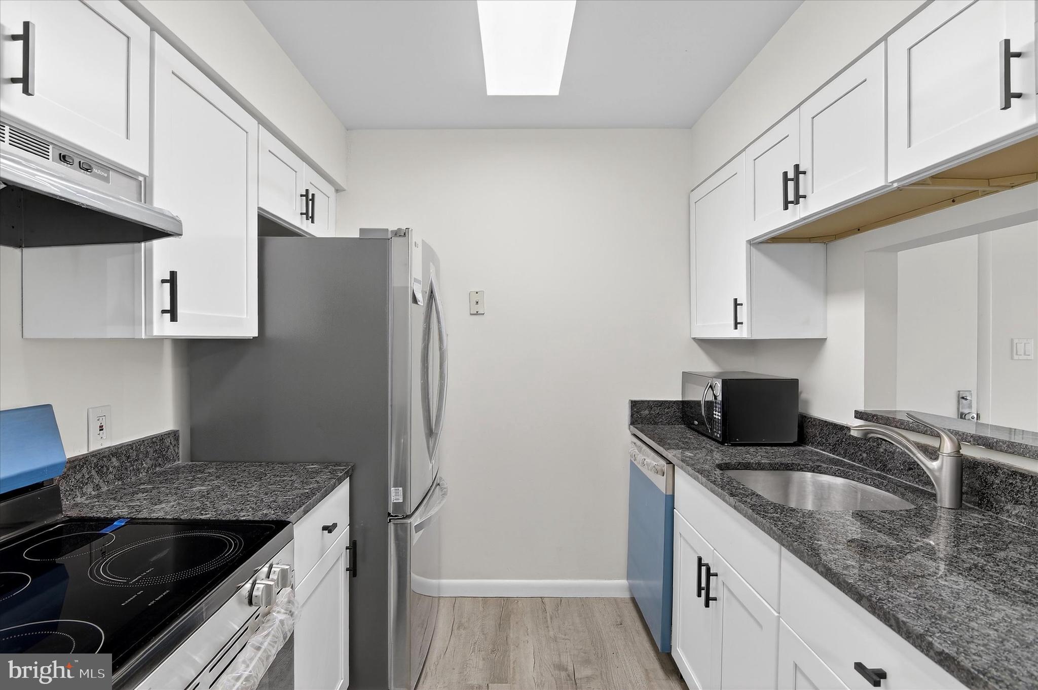 10340 Luria Commons Court, Unit 3H Burke, VA 22015 - Photo 8 of 21 a kitchen with granite countertop a sink stove and refrigerator