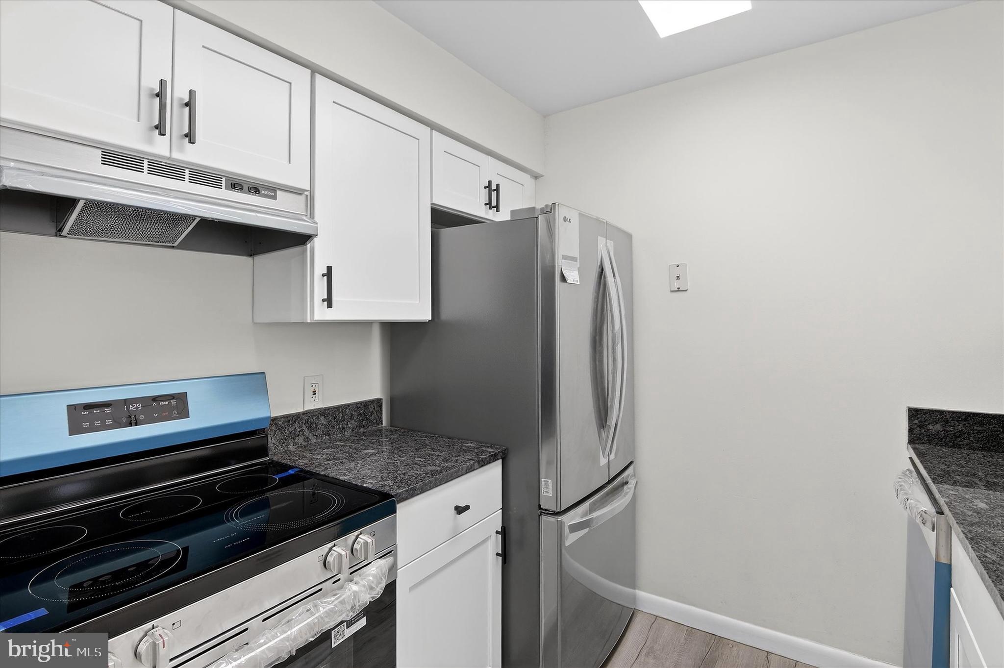 10340 Luria Commons Court, Unit 3H Burke, VA 22015 - Photo 9 of 21 a kitchen with stainless steel appliances a refrigerator a stove and white cabinets