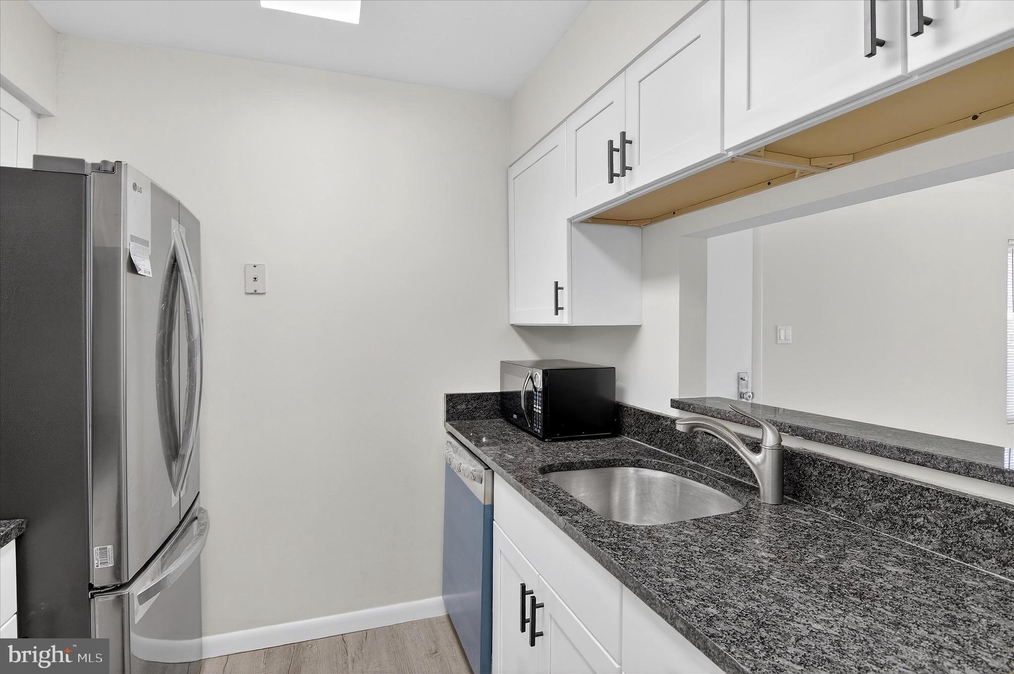 10340 Luria Commons Court, Unit 3H Burke, VA 22015 - Photo 10 of 21 a kitchen with stainless steel appliances granite countertop a sink a refrigerator and a granite counter tops