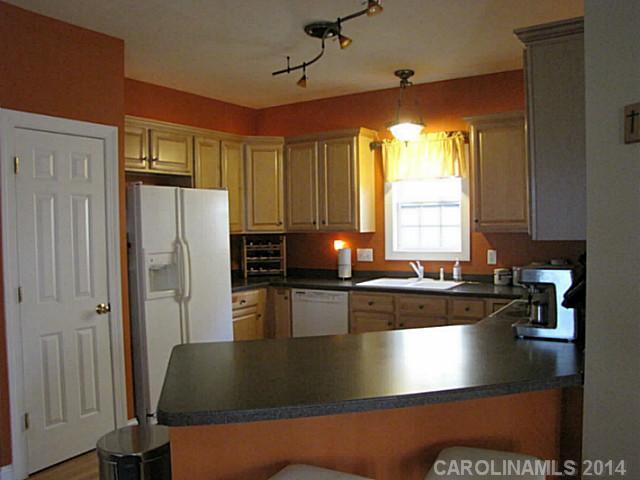 14112 Wild Elm Road Charlotte, NC 28277 - Photo 5 of 16 a kitchen with stainless steel appliances granite countertop a refrigerator a sink dishwasher a stove a dining table and chairs with wooden floor