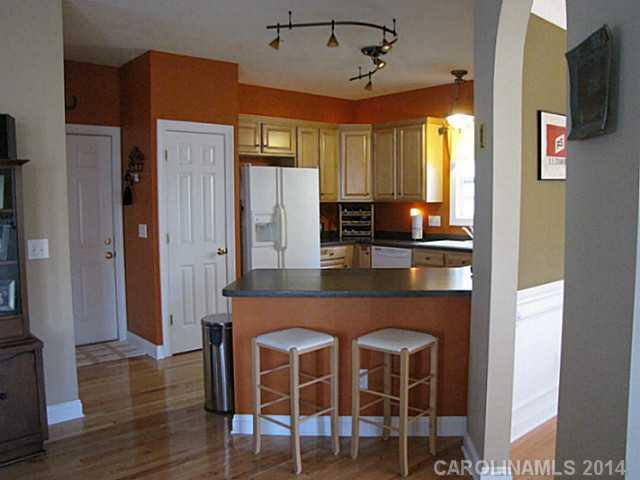 14112 Wild Elm Road Charlotte, NC 28277 - Photo 7 of 16 a kitchen with stainless steel appliances a dining table chairs and wooden floor