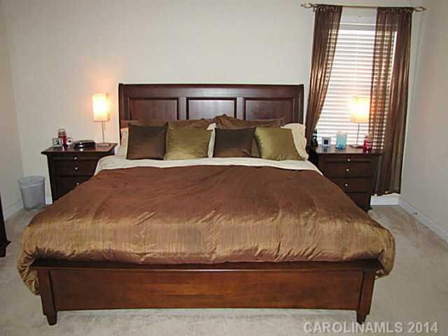 14112 Wild Elm Road Charlotte, NC 28277 - Photo 8 of 16 a large bed sitting in a bedroom next to a window