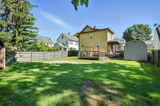a view of a house with backyard and a sitting area