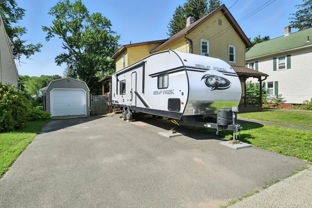 a white house that has a tree in front of it