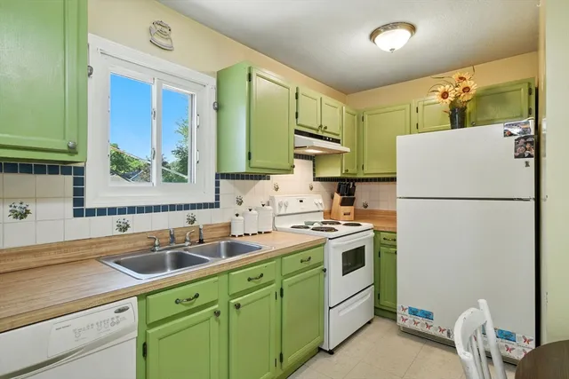 a kitchen with a sink a refrigerator and cabinets