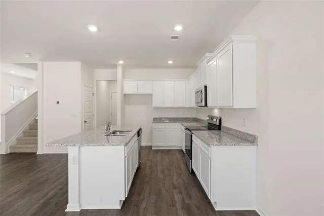 a kitchen with granite countertop white cabinets and white appliances