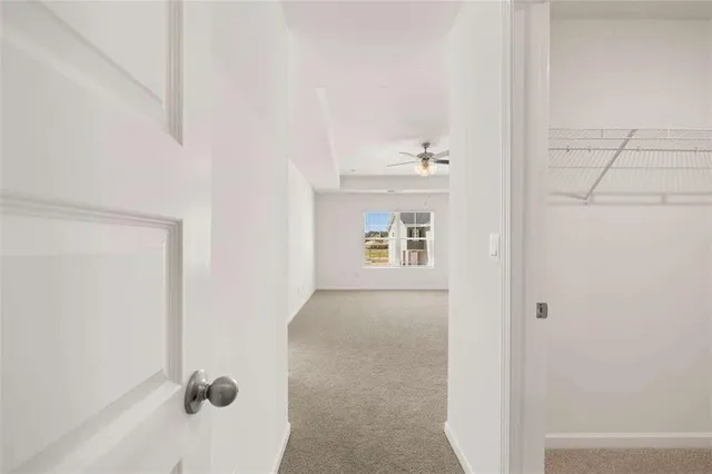 an empty room with a window and a ceiling fan