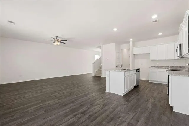 a view of kitchen with granite countertop stainless steel appliances sink and cabinets