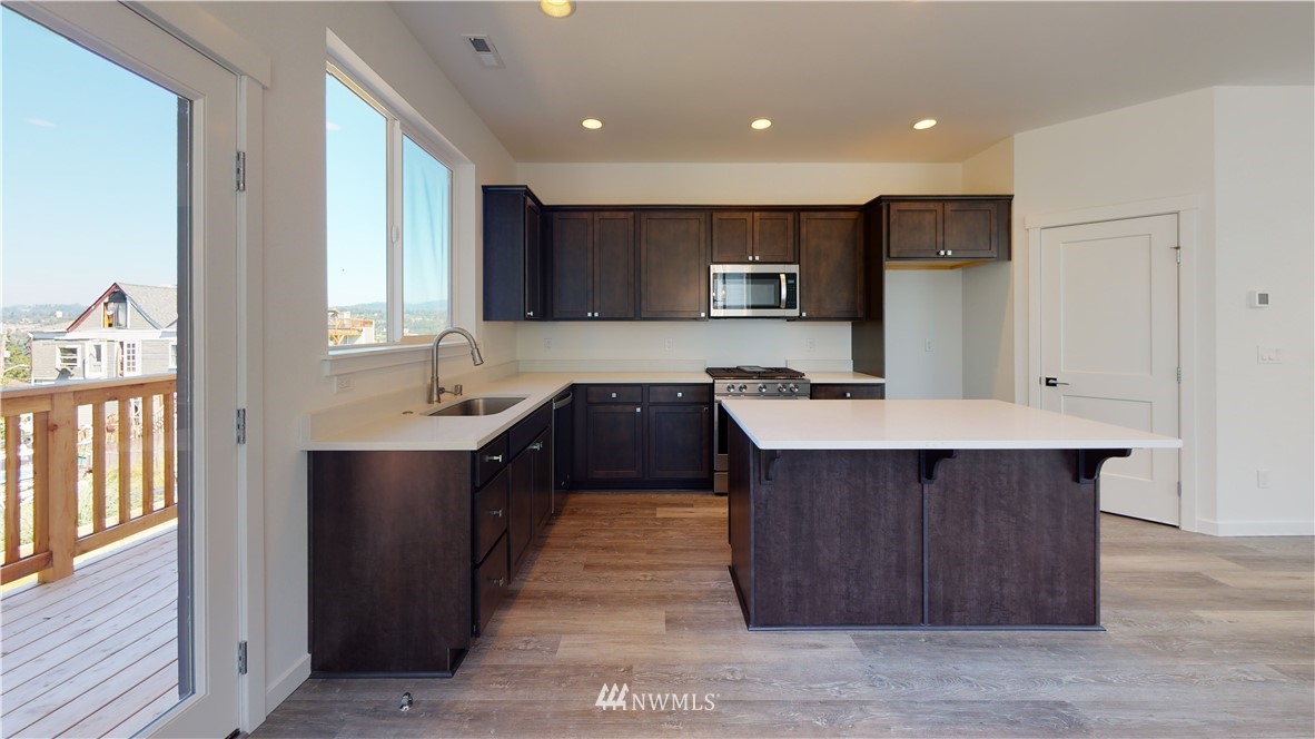 320 South 48th Street, Unit H19 Renton, WA 98055 - Photo 6 of 29 a kitchen with kitchen island a sink stainless steel appliances and cabinets