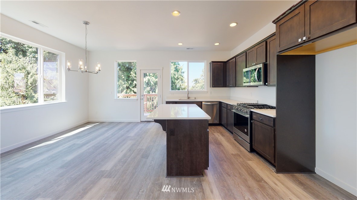 320 South 48th Street, Unit H19 Renton, WA 98055 - Photo 9 of 29 a large kitchen with stainless steel appliances granite countertop a stove a sink and a refrigerator