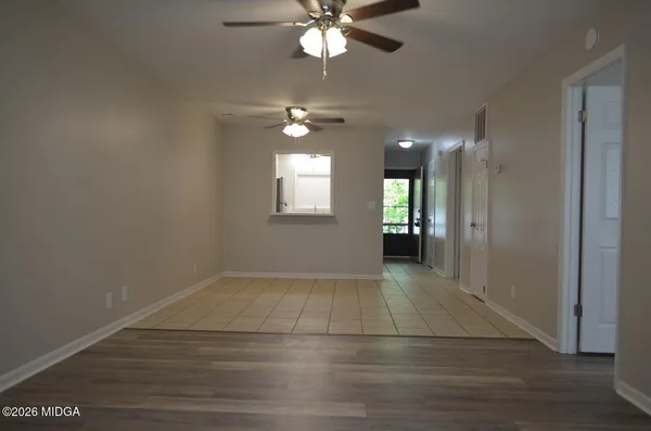 an empty room with fan and windows