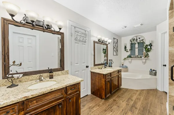 a spacious bathroom with a granite countertop sink and a mirror