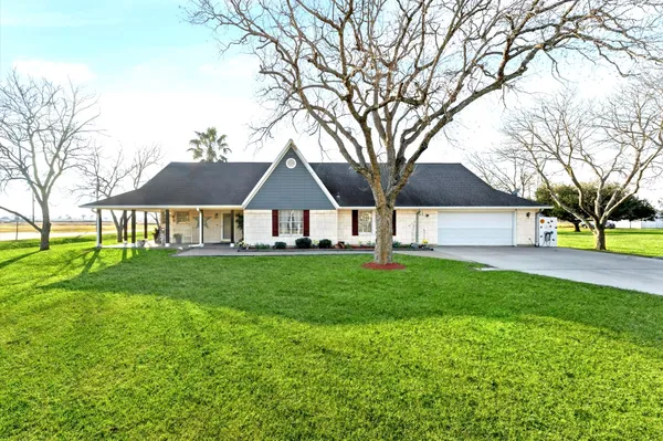 a view of an house with backyard and a tree