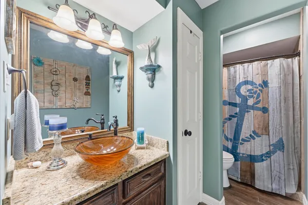 a bathroom with a granite countertop sink and a mirror