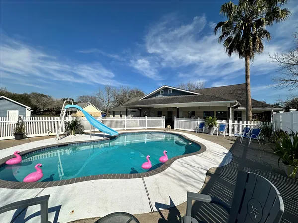 a view of a patio with swimming pool and sitting area