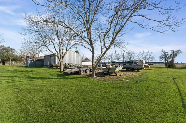 a view of grassy field with benches and trees all around
