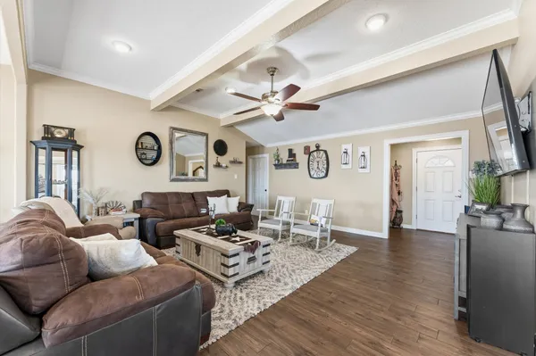 a living room with furniture kitchen view and a window