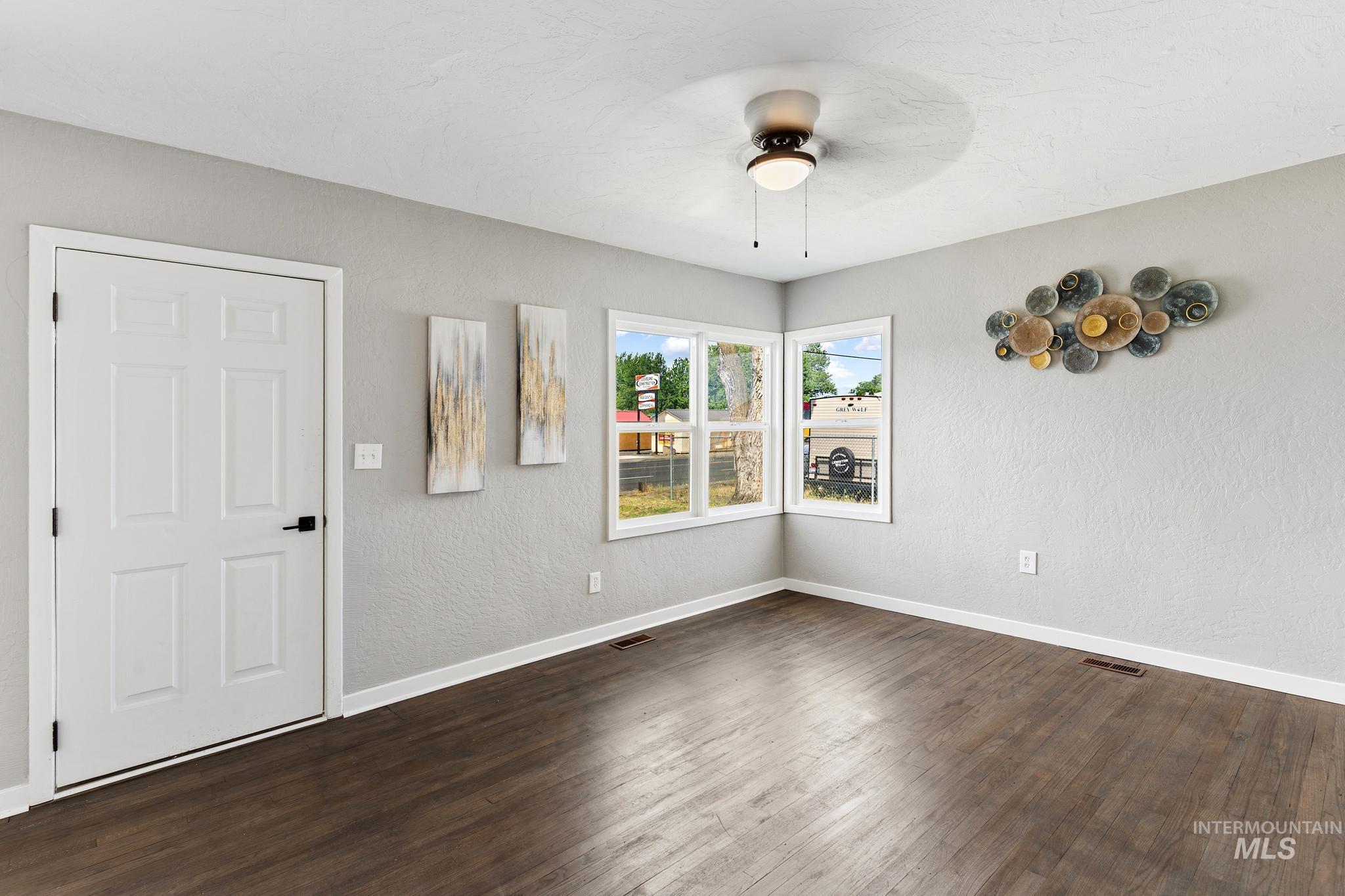 619 Thain Road Lewiston, ID 83501 - Photo 7 of 44 Spacious room featuring wood-finish flooring, light gray walls, and white trim
