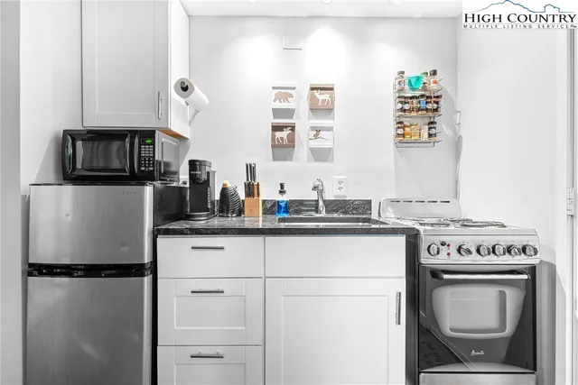 a kitchen with a refrigerator sink stove and microwave