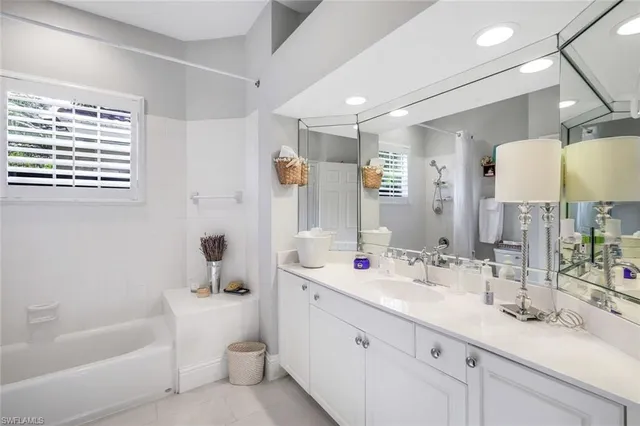 a bathroom with a sink double vanity tub and a mirror