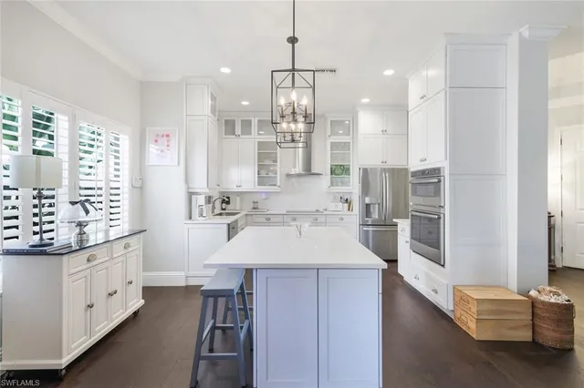 a kitchen with kitchen island granite countertop lots of counter top space and refrigerator
