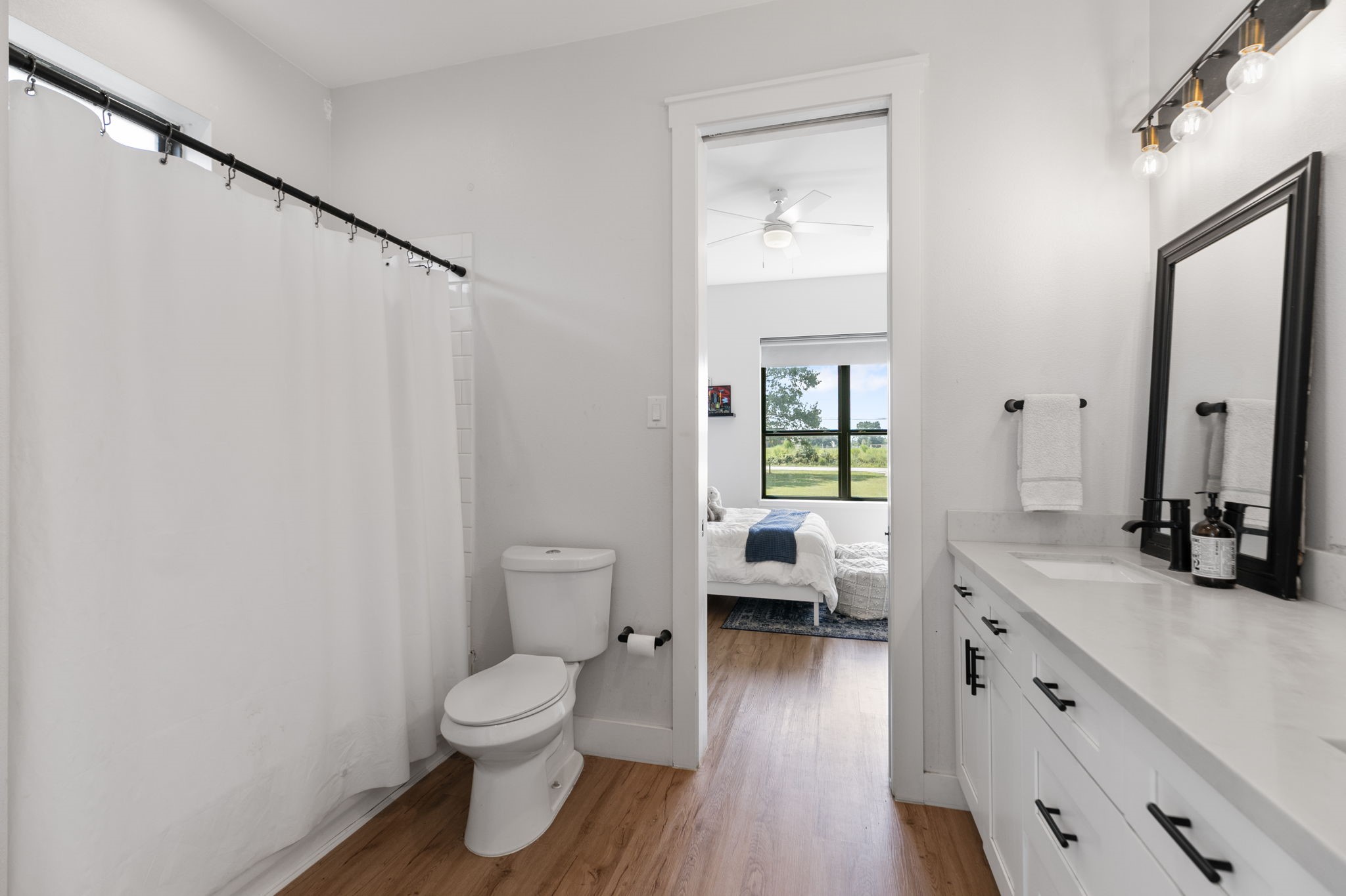 1400 Hicks Street Tomball, TX 77375 - Photo 27 of 45 a bathroom with a toilet a sink and a large mirror