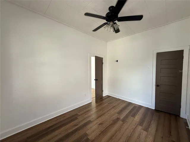 a view of room with hardwood floor and ceiling fan