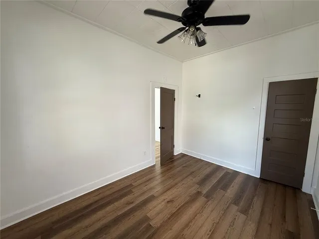 a view of an empty room with wooden floor