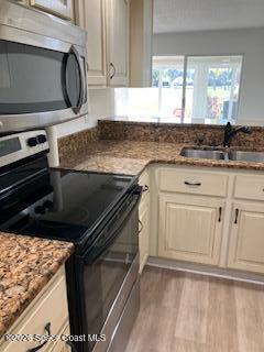 153 Augusta Way Melbourne, FL 32940 - Photo 27 of 38 a kitchen with granite countertop a sink stove and cabinets