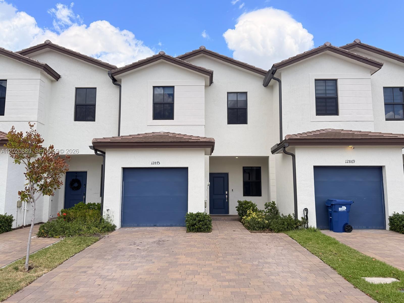 12875 Southwest 231st Terrace Miami, FL 33170 - Photo 1 of 25 a front view of a house with a yard and garage