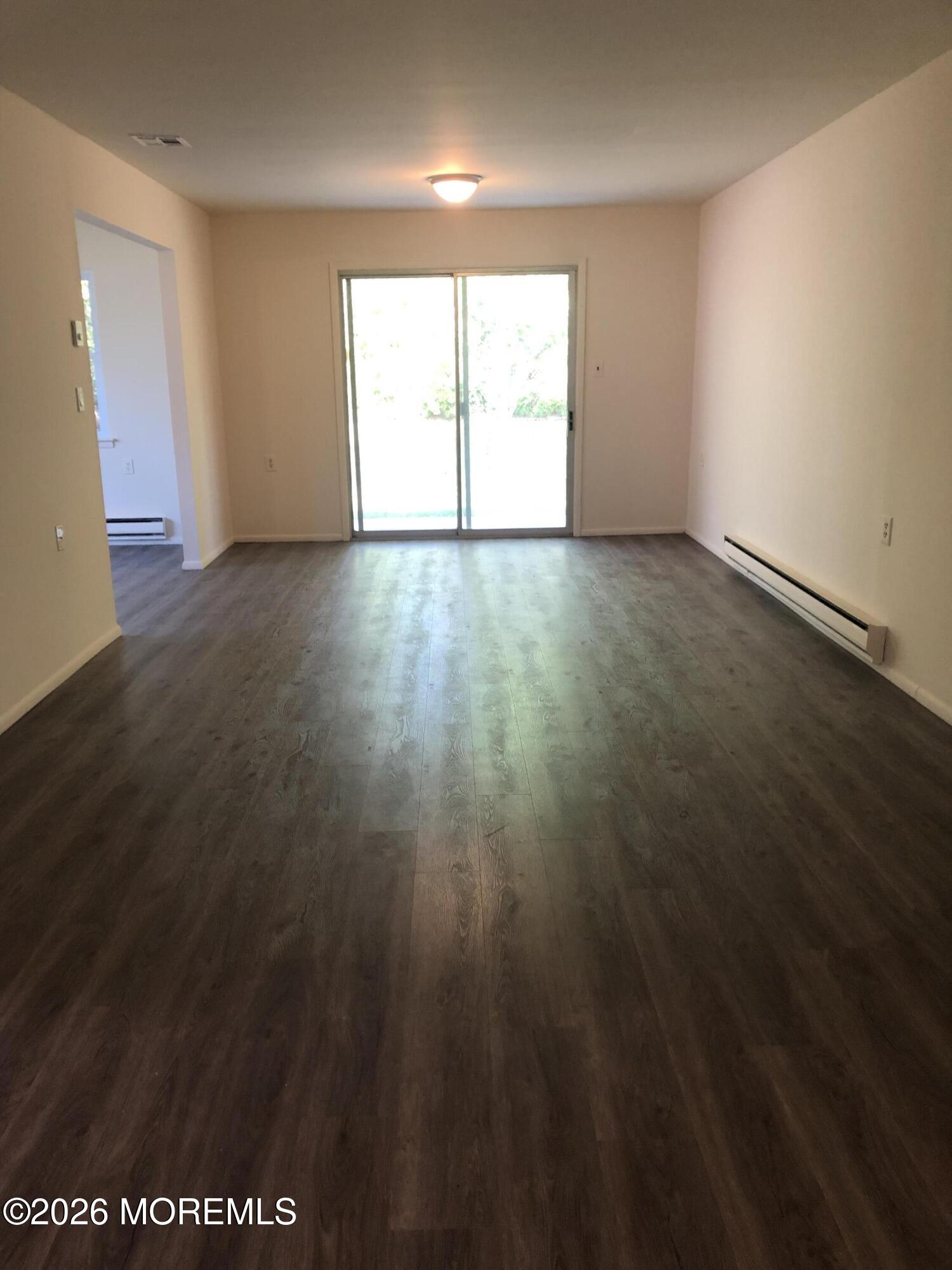 6 Dickinson Road Brick, NJ 08724 - Photo 7 of 17 an empty room with wooden floor and windows
