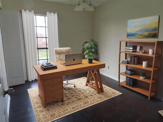 a view of a workspace with furniture and a window