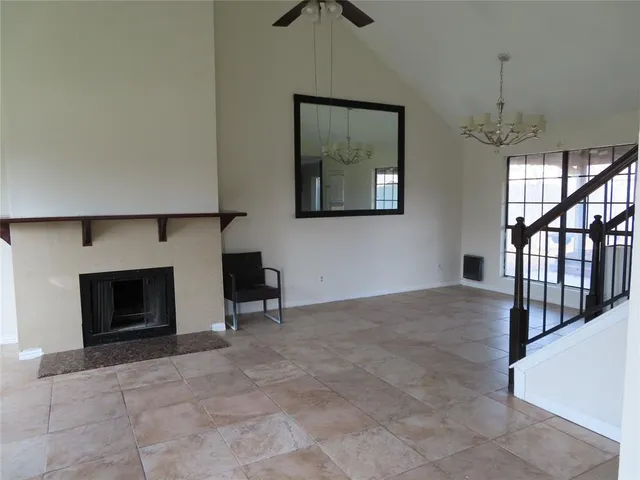 a view of an empty room with a fireplace and a window
