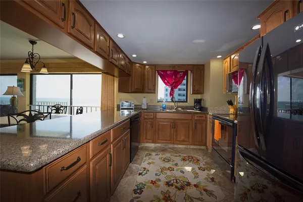a open kitchen with stainless steel appliances granite countertop a sink stove and refrigerator