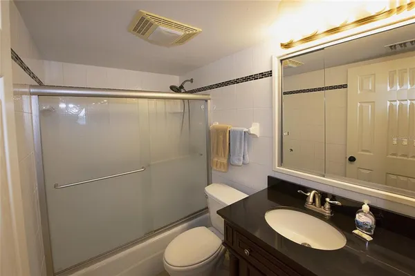a bathroom with a sink toilet a mirror and shower