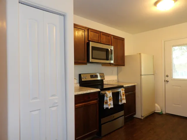 a kitchen with stainless steel appliances granite countertop a stove a microwave and a refrigerator