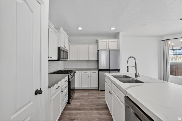 14771 Haddington Road Draper, UT 84020 - Photo 9 of 44 Kitchen featuring white shaker cabinetry, stainless steel appliances, a double basin sink, and wood-finish flooring