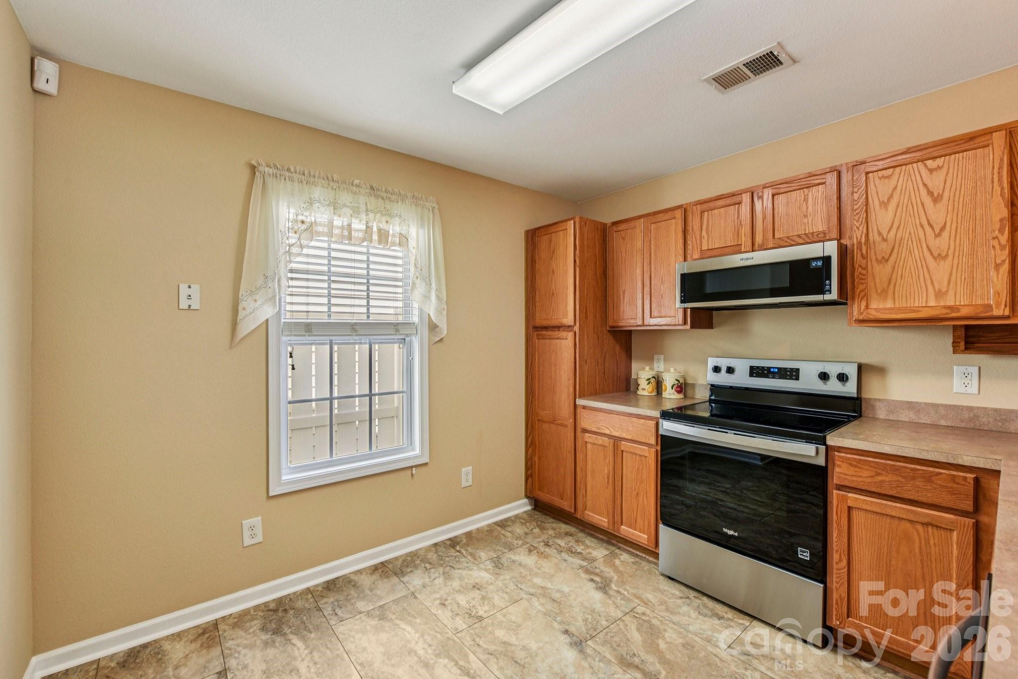 3741 Capris Lane Fort Mill, SC 29707 - Photo 6 of 22 a kitchen with granite countertop a stove top oven microwave and cabinets