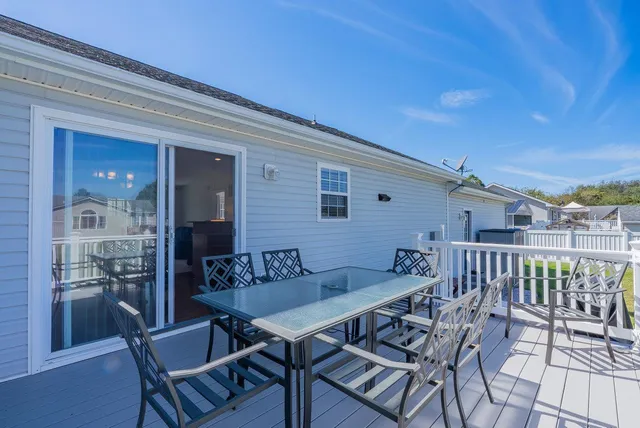 a view of a white house with a big yard and large trees
