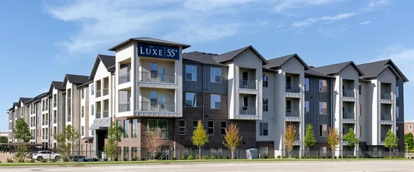 a front view of a residential apartment building with a yard