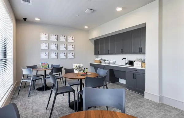 a kitchen with a dining table chairs and a refrigerator