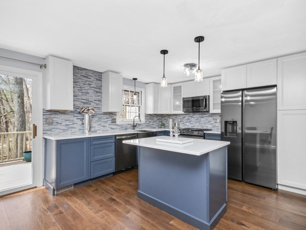 a kitchen with kitchen island granite countertop a sink stainless steel appliances and cabinets