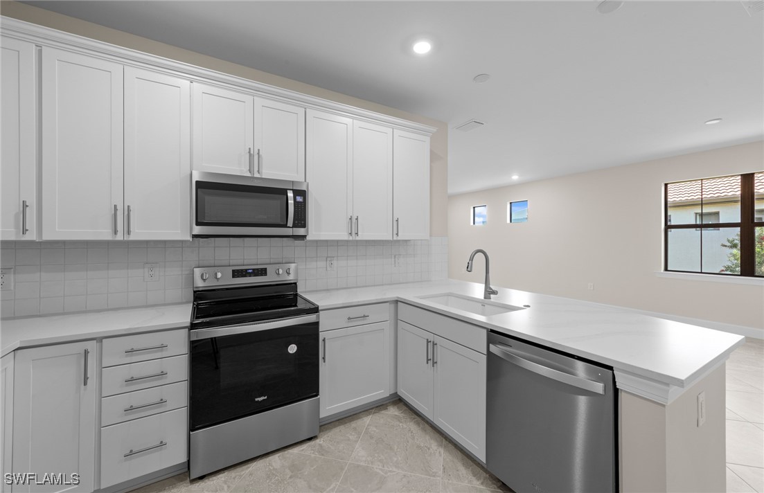 16784 Rolling Rock Boulevard Alva, FL 33920 - Photo 5 of 29 a kitchen with white cabinets stainless steel appliances and sink